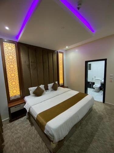 a large bedroom with a large bed with purple lighting at تميز المروة - حي المروة in Jeddah