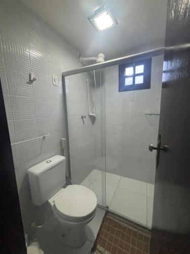 a bathroom with a toilet and a glass shower at Chalé Suiço Bananeiras in Bananeiras