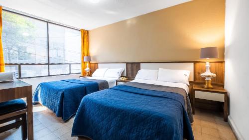 a hotel room with two beds and a window at Hotel Mariscal in Mexico City