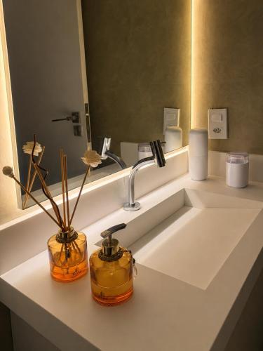 a bathroom with a sink with two vases on it at Lua prime residence in Petrolina