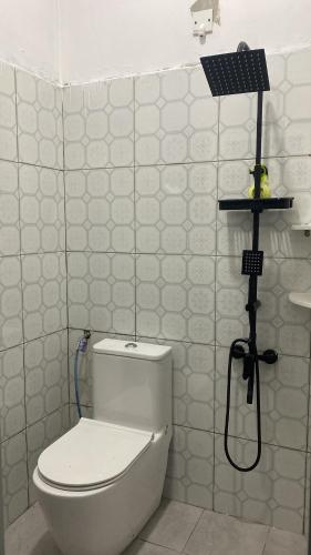 a bathroom with a white toilet and a shower at Singgah Salam Stay in Parit Raja