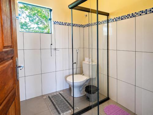 a bathroom with a toilet in a glass enclosure at Pousada Efraim in Tiradentes