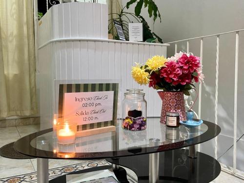 a glass table with a candle and flowers on it at La Casa Hostal Vijes in Vijes