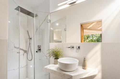 a white bathroom with a sink and a shower at Porto Cervo Sea and Nature Villa in Porto Cervo