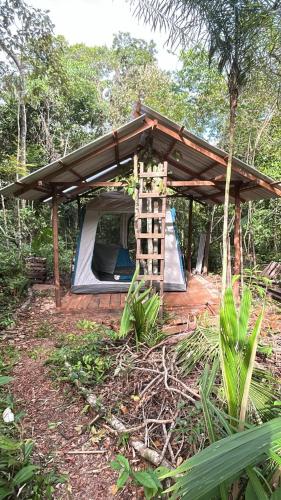 a tent with a roof and a slide in a forest at Camping AlterArte Ecovila in Santarém