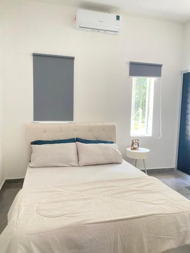 a bedroom with a large white bed with a window at Singgah Salam Stay in Parit Raja