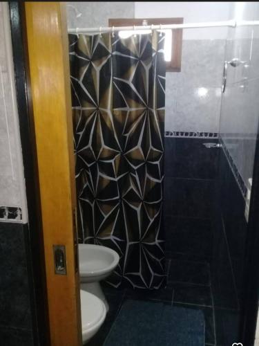 a bathroom with a toilet and a glass shower at Departamento Cura Brochero in Villa Cura Brochero