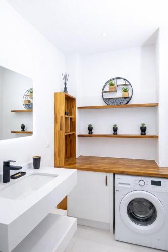 a white laundry room with a sink and a washing machine at L' É'sens Karaïbes in Les Abymes