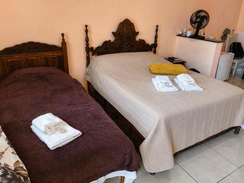 a bedroom with two beds with towels on them at Pousada Efraim in Tiradentes