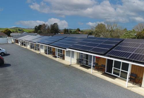 a row of buildings with solar panels on the roof at Twin Coast Adventures Motel & Cycle Hire in Kaikohe