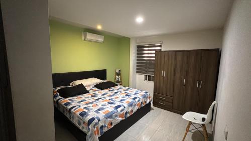 a bedroom with a bed and a cabinet and a chair at Habitaciónes Entradas Privadas independientes tipo APTO in Valledupar