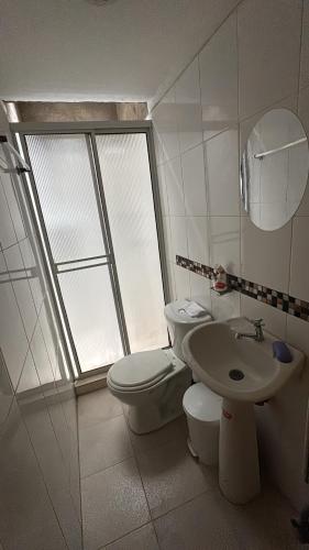 a white bathroom with a toilet and a sink at Habitaciónes Entradas Privadas independientes tipo APTO in Valledupar
