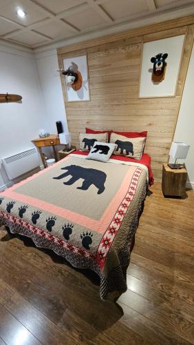 a bedroom with a bed with a bear blanket at Suite 3 Flèche du fjord vue Saguenay Mont Valin in Saint-Fulgence