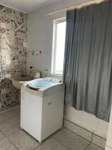 a bathroom with a sink and a shower curtain at Apartamento - Vila Isa in Governador Valadares