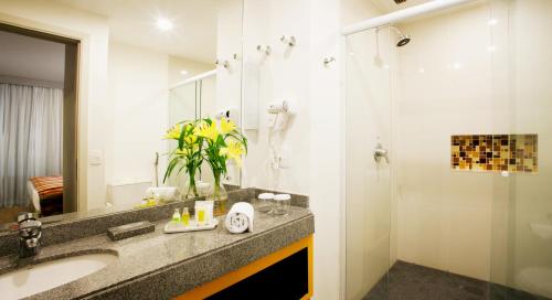 a bathroom with a sink and a shower at Quality Suites Alphaville in Barueri