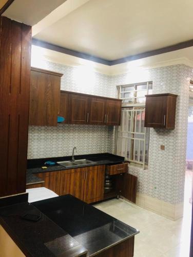 a kitchen with wooden cabinets and a sink at Ni HOME & RELAX in Ruhengeri