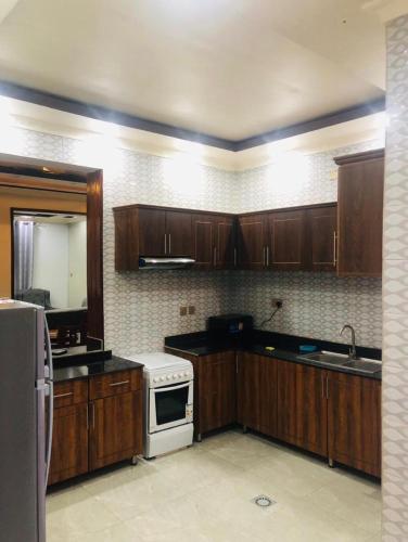 a kitchen with wooden cabinets and a white stove top oven at Ni HOME & RELAX in Ruhengeri