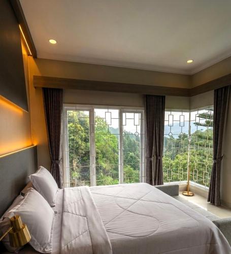 a bedroom with a large bed and a large window at Al Andalus Resort Puncak in Puncak
