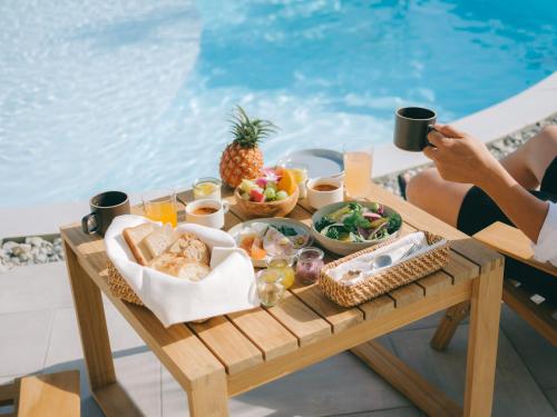 a tray of food on a table next to a pool at semilla 名護 沖縄 in Nago