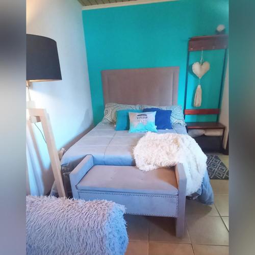 a bedroom with a bed and a blue wall at Studio Monoambiente Urbano en radar centrico,completo y funcional con Alexa in Ushuaia