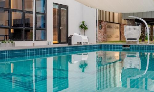 a swimming pool with two chairs in a building at Aldea de Pangsion Pool Villa in Pohang