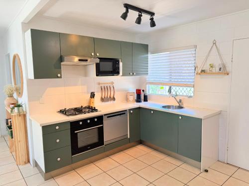 a kitchen with green cabinets and a sink at 'Your Place on Davidson' in Mount Isa