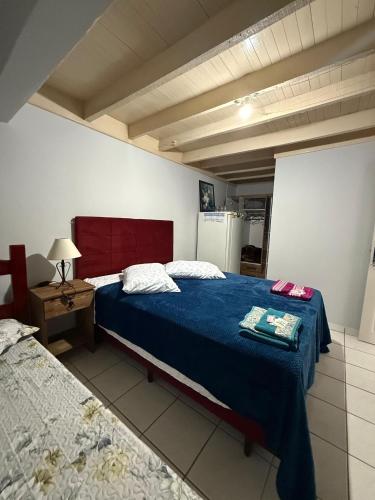 a bedroom with two beds and a table with a lamp at Casa Miguel in Lauro Müller