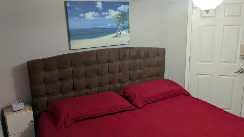 a bedroom with a bed with red pillows and a painting at Whale Hill Escape - Beach Views and Walk to Mannys in Puerto Peñasco