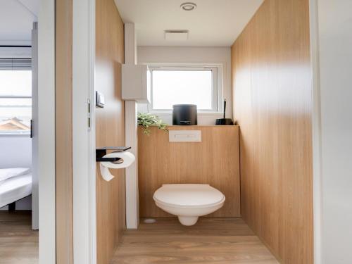a small bathroom with a toilet and a window at Cozy Caravan in Berlare for 6 people in Berlare