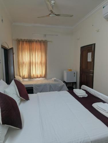 a hotel room with two beds and a window at HILL TOP HOMES in Kannur
