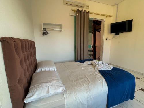a bed sitting in a room with a tv at Pousada Mel e Mar in Penha