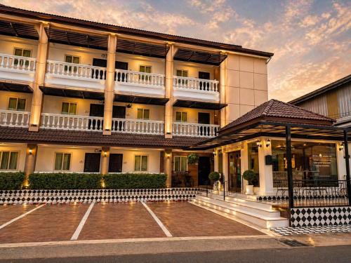 a building with a parking lot in front of it at The Lion King Hotel by Thai Baan Ozone Udonthani in Udon Thani