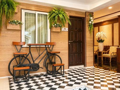 a bike parked next to a house with a checkered floor at The Lion King Hotel by Thai Baan Ozone Udonthani in Udon Thani