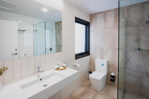 a bathroom with a sink and a toilet and a shower at 13th Beach Golf Lodges in Barwon Heads