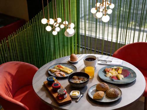 a table with plates of breakfast food on it at Hotel Indigo Alishan by IHG in Fanlu