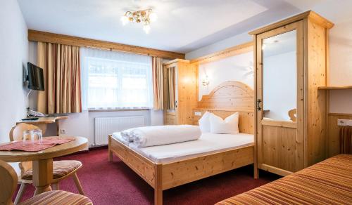 a hotel room with a bed and a table at Apart Garni Elfrieda in Ischgl