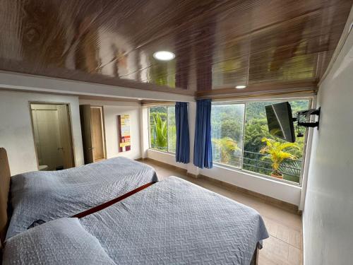 a bedroom with two beds and a large window at Finca Altamira in La Vega