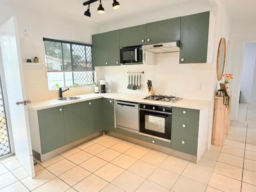 a kitchen with green cabinets and a tile floor at Another 'Your Place on Davidson!' in Mount Isa