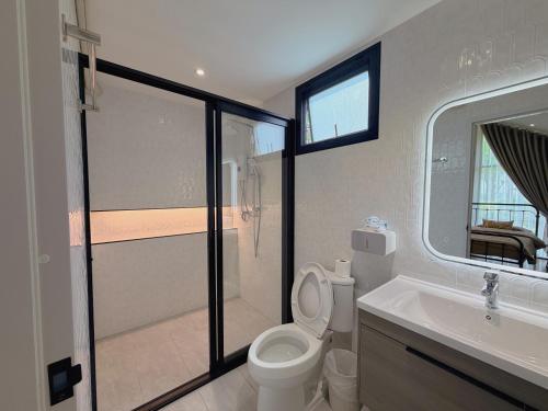 a bathroom with a toilet and a sink at Four Moon Khaoyai in Pong Talong