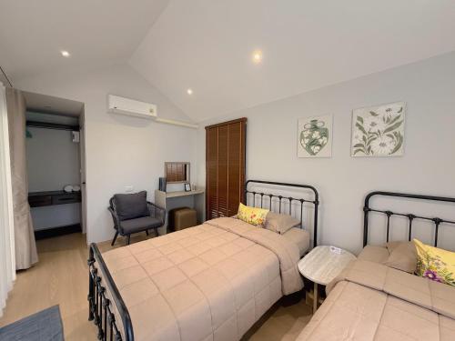 a hotel room with two beds and a chair at Four Moon Khaoyai in Pong Talong