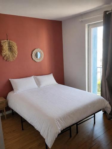 a bedroom with a large white bed in front of a window at Appartement 2 chambres, centre ville, proche mer in Saint-Nazaire