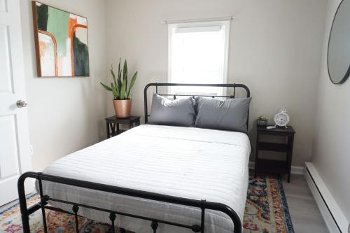 a bedroom with a bed with white sheets and a window at Gateway Getaways in Hagerstown