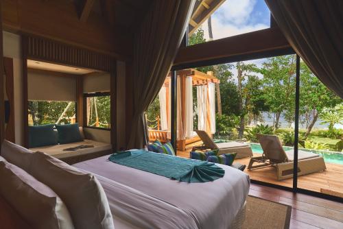 a bedroom with a bed and a living room at Ma'oni Seascape Villas in Panglao Island
