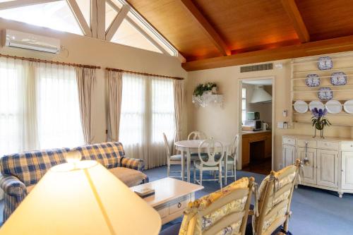 a living room with a couch and a table at フォレストヒルズガーデン in Mihara