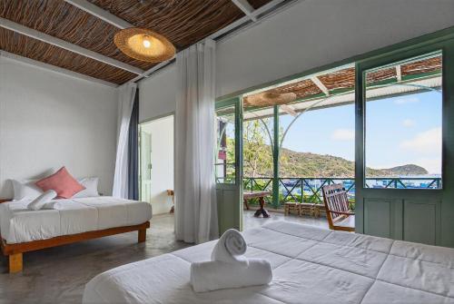 a bedroom with a bed and a view of the ocean at Chành Rành House in Vĩnh Hy