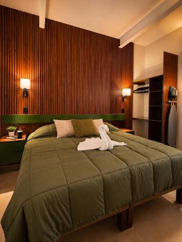 a bedroom with a large bed with a towel on it at El Suburbio - Aldama in Morelia