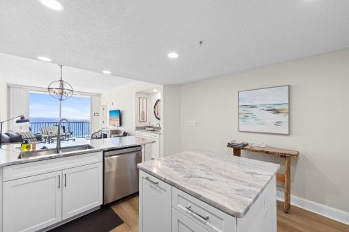 a kitchen with white cabinets and a large counter top at Majestic Resort! Newly Updated Beachfront 3BR Condo in Panama City Beach