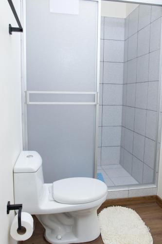 a bathroom with a white toilet and a shower at Zentra Plaza Hotel & Cowork in Chiclayo