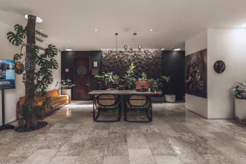 a room with a table and some plants in it at Monolocale Resort & Spa Seminyak by Ini Vie Hospitality in Seminyak