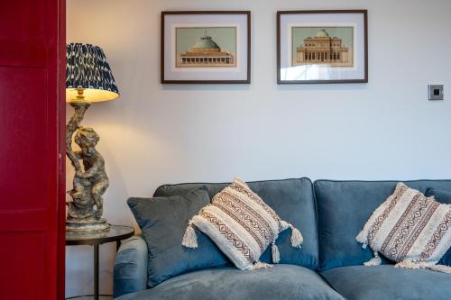 a blue couch in a living room with two pillows at High Street Hideaway Cheltenham in Cheltenham